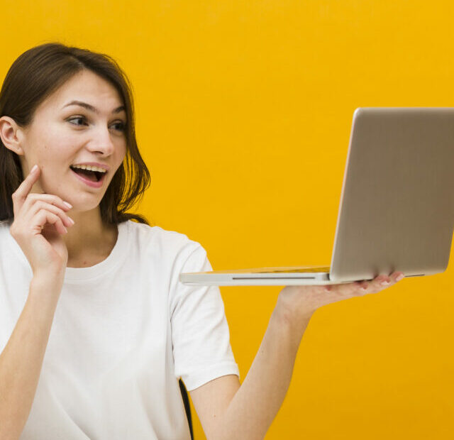 cropped-front-view-of-woman-at-desk-enjoying-what-she-sees-on-her-laptop-with-copy-space.jpg
